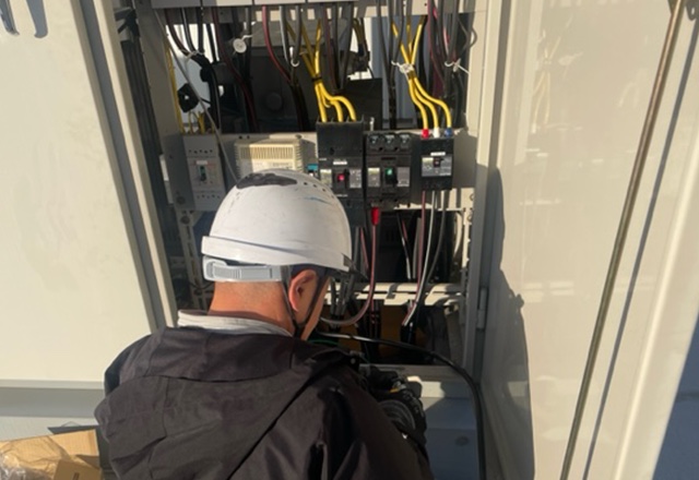 電気設備の盤内を確認する作業員